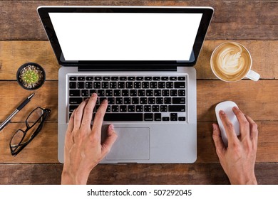 Business Man Hand Working With Blank Screen Laptop Computer And Holding Mouse On Rustic Wooden Table . Top View.