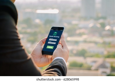 Business Man Hands Hold Mobile Banking On Smart Phone On Blurred Urban City As Background