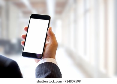Business man hands holding blank screen smartphone in corridor office.