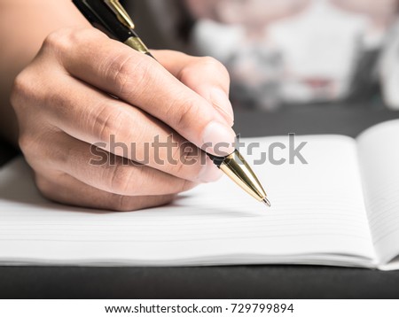 Business man Hands with pen writing on paper in close up view