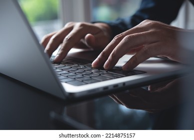 Business man hands typing on laptop computer keyboard, searching information, surfing the internet on dark office desk, distance job, online working, business and technology concept - Shutterstock ID 2214875157