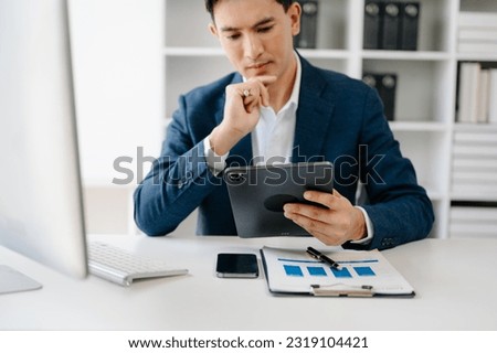 Business man hands is typing on a laptop and holding smartphone at modern ffice
