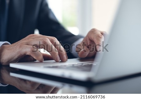 Business man hands typing and surfing the internet, searching the information via laptop computer, close up. Businessman online working at modern office, business and technology concept