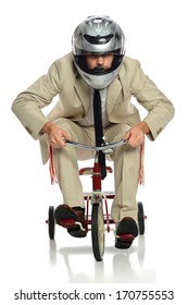 Business Man With Helmet Riding Child's Tricycle Isolated Over White