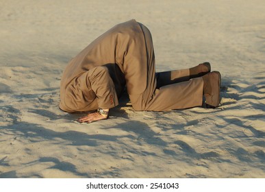 business man with his head buried in the sand