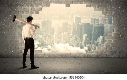 Business man hitting wall with hammer on city view background