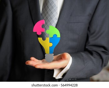 business man hold a puzzles of bulb - Shutterstock ID 564994228
