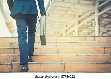 Business man holding a briefcase walking up the stairs in the routine of working with determination and confidence. - Shutterstock ID 577460224