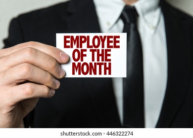 Business Man Holding A Card With The Text: Employee Of The Month