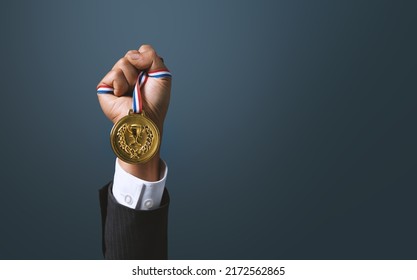 A business man holding a gold medal. Achieving success in business and achieving business goals. 