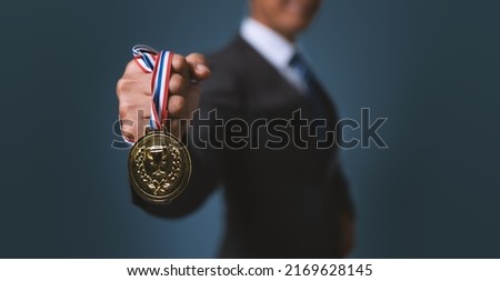 A business man holding a gold medal. Achieving success in business and achieving business goals. 