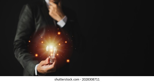 a business man holding a light bulb and the light shines out-New creativity.tif