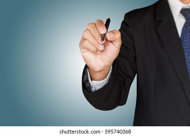 Business man holding a pen on green background - Powered by Shutterstock