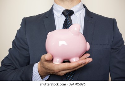 Business Man Holding A Piggy Banck