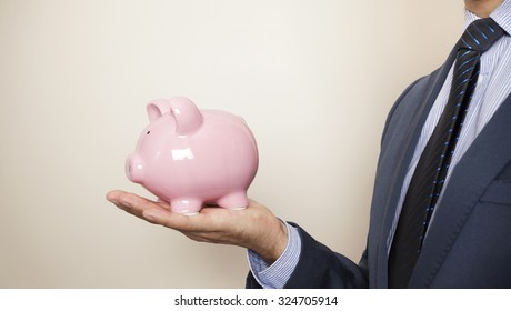 Business Man Holding A Piggy Banck