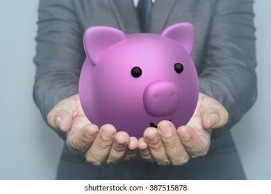 Business Man Holding A Piggy Banck