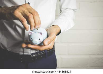 Business Man Holding A Piggy Banck