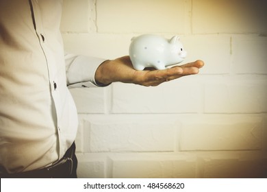 Business Man Holding A Piggy Banck