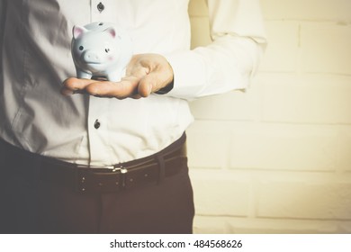 Business Man Holding A Piggy Banck