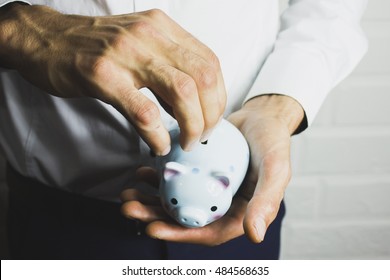 Business Man Holding A Piggy Banck