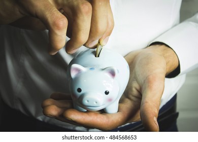 Business Man Holding A Piggy Banck