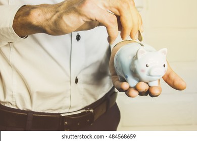 Business Man Holding A Piggy Banck