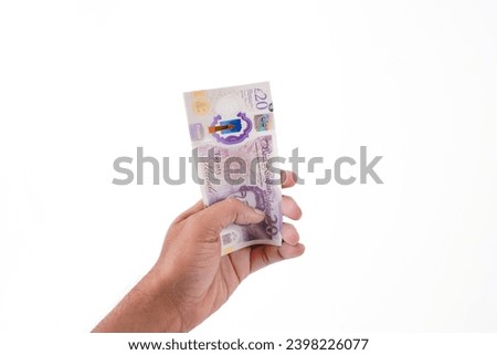 Business man holding several 20 pounds bank notes isolated on white background