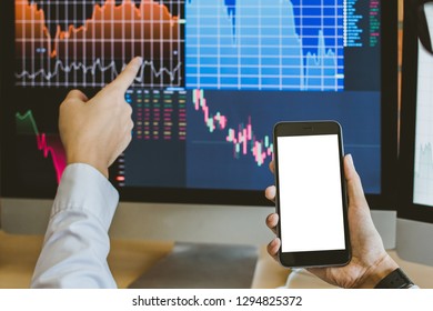 Business Man Holding Smart Phone White Screen And  Pointing And Look Directions Change Average Line Share Price Movement Stock Trading In The Up And Down. On Display Computer. 