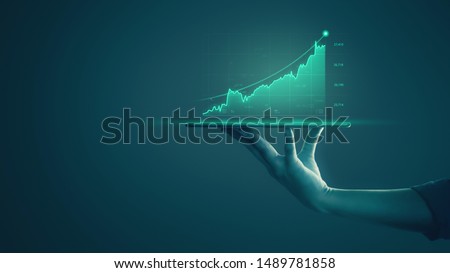 Business man holding tablet and showing holographic graphs and stock market statistics gain profits. Concept of growth planning and business strategy. Display of good economy form digital screen.