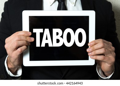 Business Man Holding Tablet With The Text: Taboo