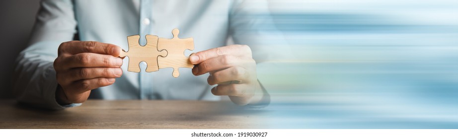 Business Man Holding Two Wooden Puzzle.