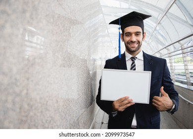 Business man is holding white board and wear graduation hat, business education concept in the cityscape - Powered by Shutterstock