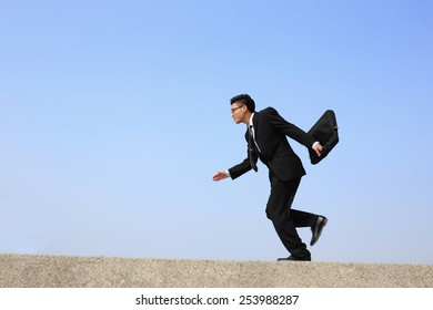 business man jump and run with blue sky background, full length, asian male - Shutterstock ID 253988287