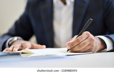 Business man lawyer executive wearing suit holding pen in hand writing in notebook or contract legal financial document, filling insurance form, taking notes, putting signature in corporate papers.