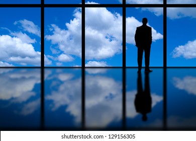 Business Man Looking Out of High Rise Office Window at Blue Sky and Clouds - Powered by Shutterstock