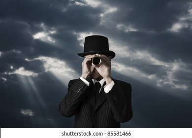 Business Man Looks Through A Telescope In Darkness