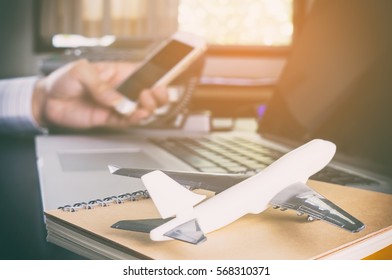 Business Man Is Making Call In Office For Global Communication. A Man Holding Mobile Phone With Airplane On For Ground For Business Travel Communication Concept.