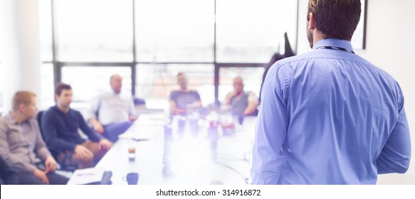 Business man making a presentation at office. Business executive delivering a presentation to his colleagues during meeting or in-house business training, explaining business plans to his employees.  - Powered by Shutterstock