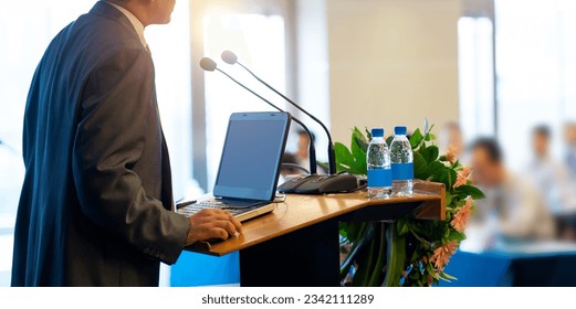 Business man making a speech at a conference hall - Powered by Shutterstock