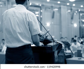 Business Man Is Making A Speech In Front Of A Big Audience At A Conference Hall.