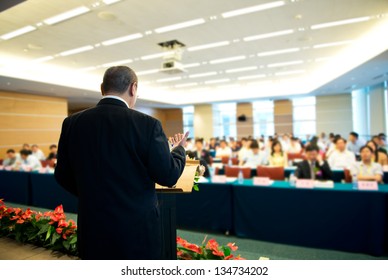 Business Man Is Making A Speech In Front Of A Big Audience At A Conference Hall.