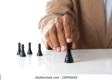 Business man moving chess figure with team behind - strategy or leadership concept