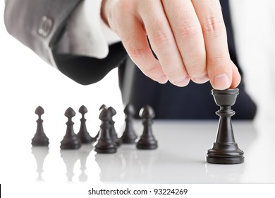 Business man moving chess figure with team behind - strategy, management or leadership concept
