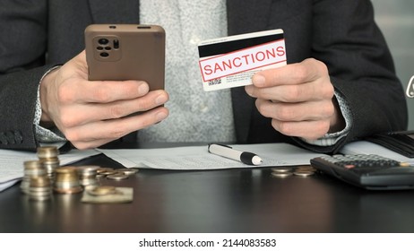Business Man is Nervous About Economic Sanctions Affecting his Bank. He is Holding Plastic Bank Card and Using Smartphone, Trying to Connect with a Bank via Mobile App