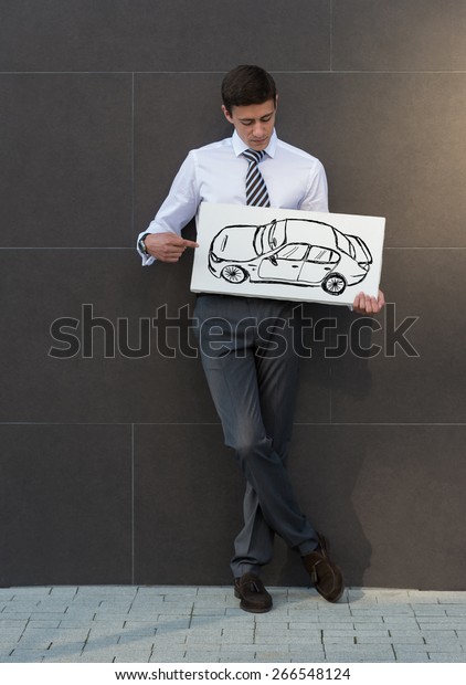 Business man with new car sign. Dealer or buyer\
showing car sign. Credit\
concept