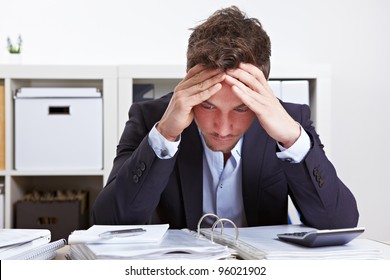 Business man in office with burnout syndrome at desk