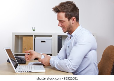 Business man in office with RSI syndrome holding his aching hand