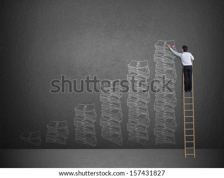 Business man on ladder drawing idea is money concept on wall