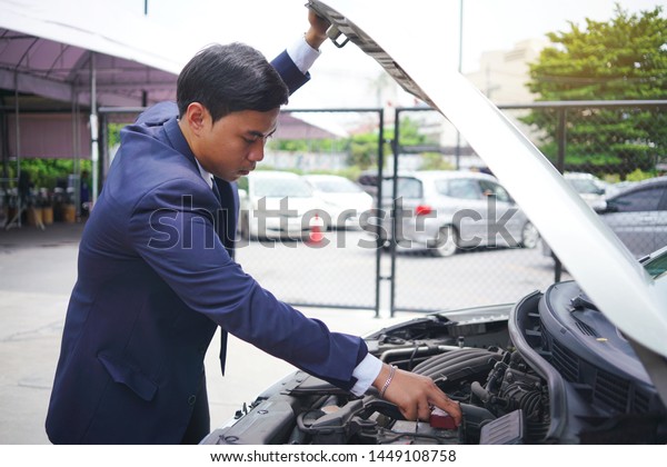 business man opened the car hood and tried\
to repair the car on street                    \
