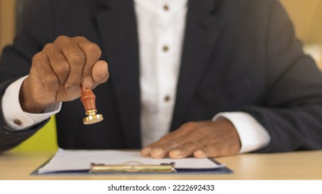 Business Man Person's Hand Stamping With Approved Stamp On Certificate Document Public Paper At Desk, Signing On Business Partner Paper To Success, Or Concept Of Attorney And Insurance